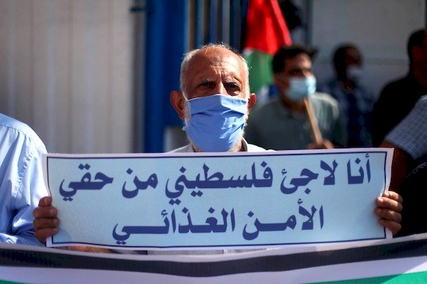 غزة: لاجئ فلسطيني يرفع يافطة تطالب وكالة اونروا بتوفير الأمن الغدائي