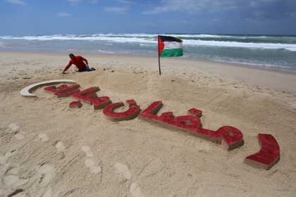 صور.. الفنان الفلسطيني محمد طوطح يرسم بالرمل "رمضان مبارك" على شاطئ بحر غزة