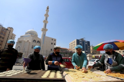 بالصور: بائعون فلسطينيون يعدون "القطايف '' الشعبية أمام قلعة برقوق في خانيونس