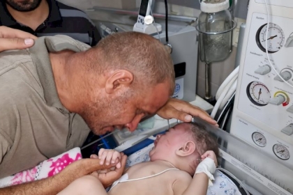 شاهد:  محمد الحديدي مع طفله الوحيد الناجي من مجزرة الاحتلال بمخيم الشاطئ غرب مدينة غزة
