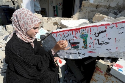 الفنانة الفلسطينية سجى موسى ٢٦ عاما ترسم على ركام منزل عائلتها المدمر خلال التصعيد الأخير