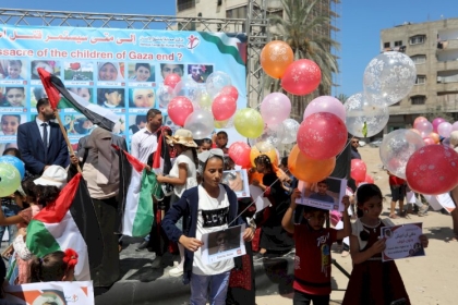 صور: أطفال يحملون البالونات ويشاركون في فعالية "أنقذوا أطفال غزة" أمام ركام منزل عائلة الكولك  في مدينة غزة
