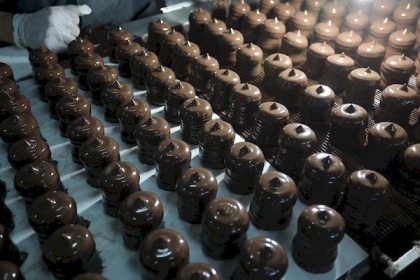 بالصور.. عمال داخل مصنع العريس بدير البلح  يتجمعون  على خط إنتاج حلوى "الشتوي"