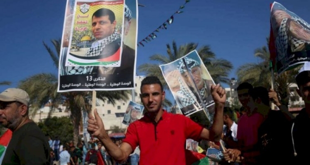 غزة: شاب فلسطيني يرفع صورة محمد دحلان في تظاهرة لحركة فتح 